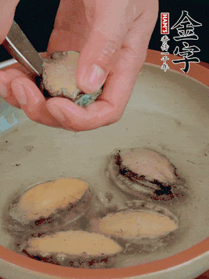 鮑魚加鹽、清水浸泡，用勺子挖出鮑魚肉。